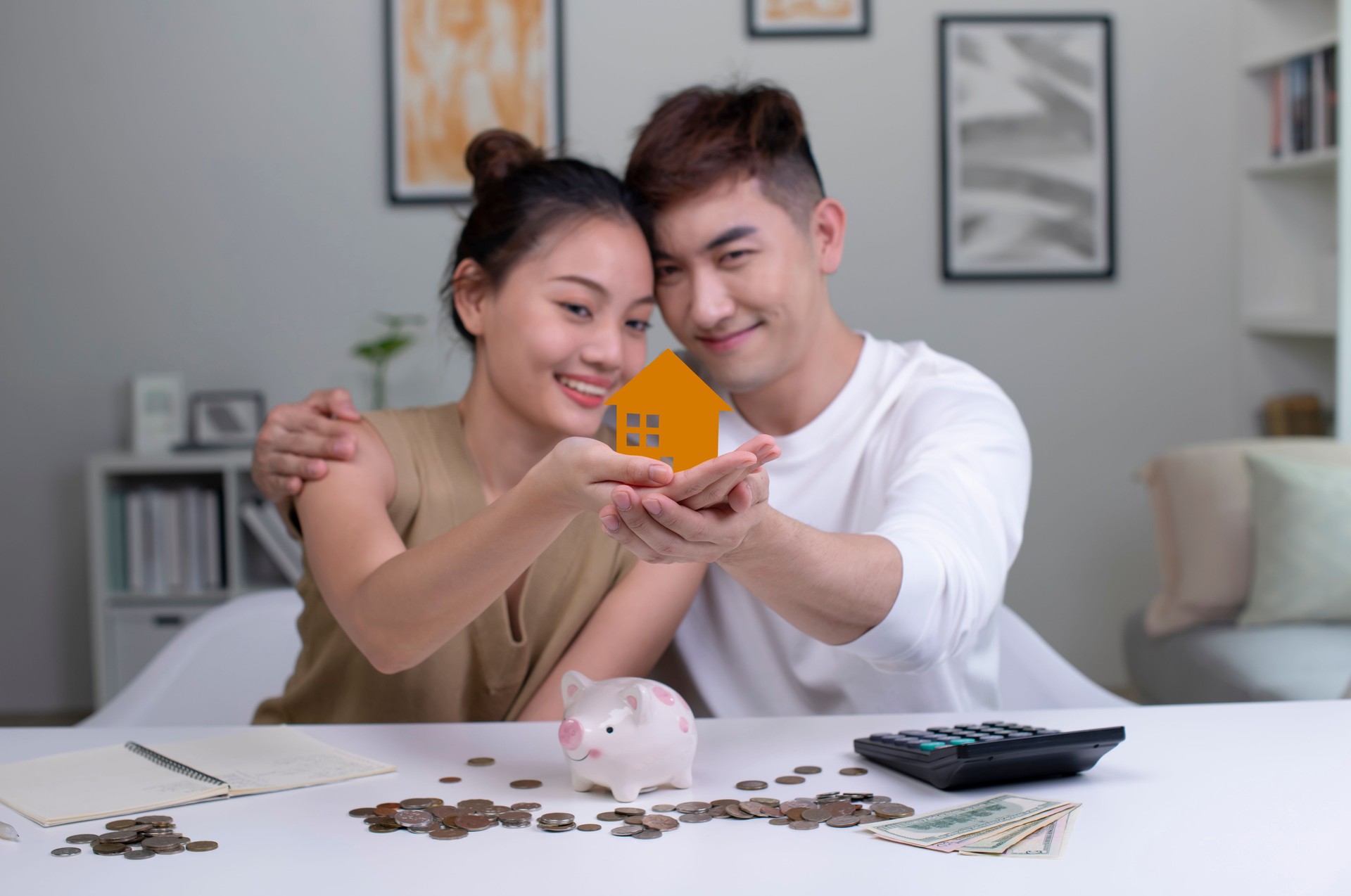 Young Asian couple saving money to buy a house.
